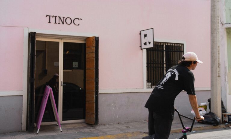 A street scene of a man on a bike near Tinoc Cafe in Merida, Mexico.