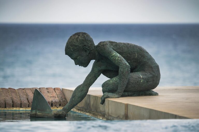 Bronze sculpture of a boy playing by the seashore in Platja d'Aro, Spain.