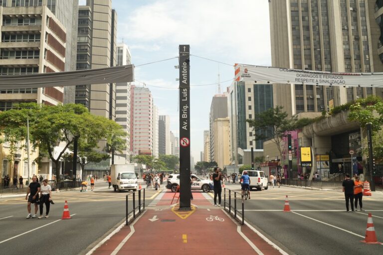 Street view of Avenida Paulista in São Paulo filled with people and traffic.