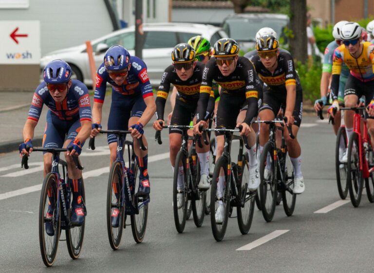 Group of cyclists racing on city streets during a competitive cycling event.