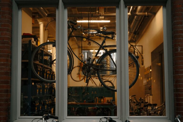 A vintage bicycle is displayed in a workshop window in Amsterdam, showcasing urban cycling culture.
