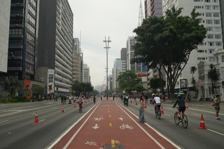 Vibrant street scene with cyclists on Avenida Paulista in São Paulo, Brazil.