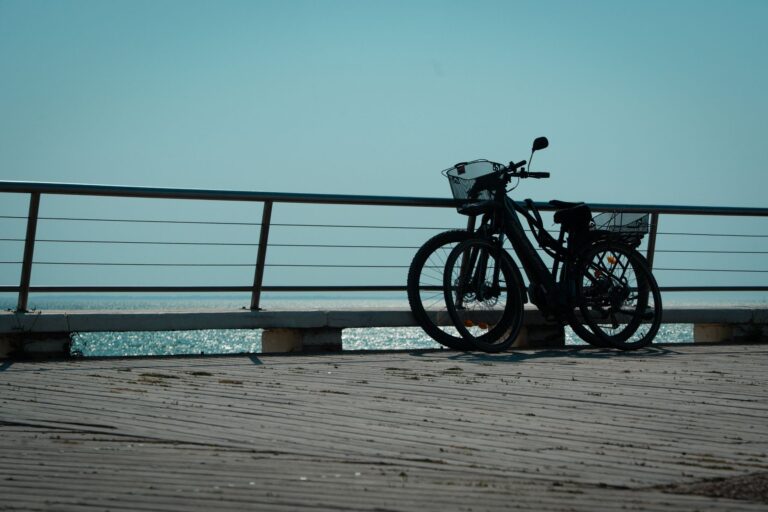 Two electric bikes parked on a seaside boardwalk in Saint-Jean-de-Monts, France, offering a serene coastal view.