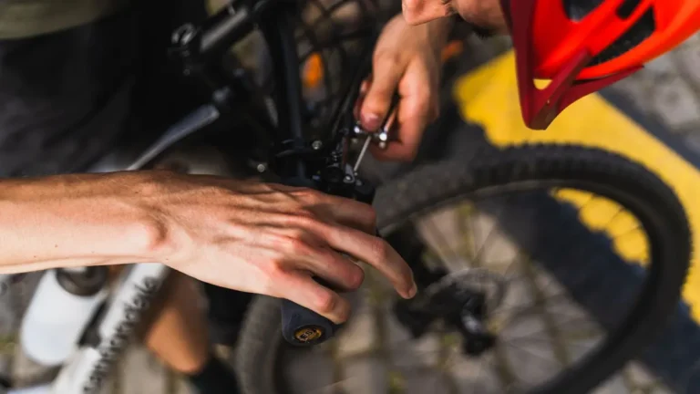 Detailed shot of a person adjusting a bicycle handlebar outdoors in daylight.