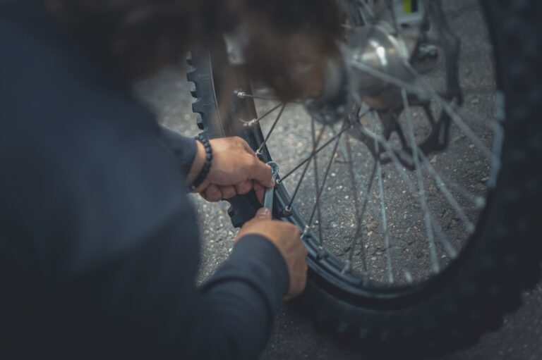 Pessoa Na Jaqueta Preta Que Segura A Roda Da Bicicleta GKLmVfcXl0o