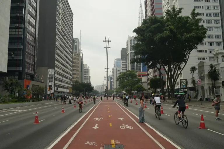 Vibrant street scene with cyclists on Avenida Paulista in São Paulo, Brazil.