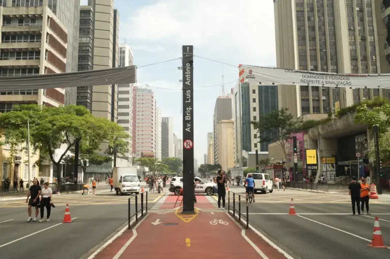 Street view of Avenida Paulista in São Paulo filled with people and traffic.